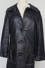 long sleeve black leather long jacket with double lapel, buttons, and white thread detail vintage 1970's
