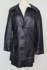 long sleeve black leather long jacket with double lapel, buttons, and white thread detail vintage 1970's