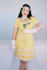 Women's vintage 1960's Miss Elliette California label short sleeve knee length yellow dress with scoop neck and cream floral applique trim.