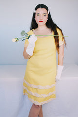 Women's vintage 1960's Miss Elliette California label short sleeve knee length yellow dress with scoop neck and cream floral applique trim.