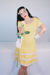 Women's vintage 1960's Miss Elliette California label short sleeve knee length yellow dress with scoop neck and cream floral applique trim.