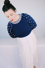 Women's vintage 1960's long sleeve midi length twofer dress with a navy cashmere top half and white polyester skirt. White beads all over top part.