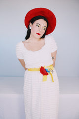 Women's vintage 1970's short sleeve maxi length white dress with tiered lace ruffles all over and an attached yellow belt with flowers