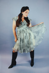 knee length sleeveless dress with ruffle neckline in a white and black polka dot print vintage 1970's