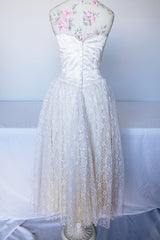 Women's vintage 1950's white lace wedding dress with cream satin bodice and lace overlay. Sweetheart neckline, strapless, zipper in the back.