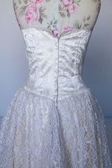 Women's vintage 1950's white lace wedding dress with cream satin bodice and lace overlay. Sweetheart neckline, strapless, zipper in the back.