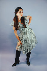 knee length sleeveless dress with ruffle neckline in a white and black polka dot print vintage 1970's