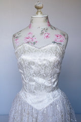 Women's vintage 1950's white lace wedding dress with cream satin bodice and lace overlay. Sweetheart neckline, strapless, zipper in the back.