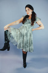 knee length sleeveless dress with ruffle neckline in a white and black polka dot print vintage 1970's