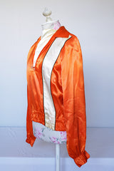 Women's or men's vintage 1940's/1950's long sleeve equestrian racing top in orange satin with one cream vertical stripe.