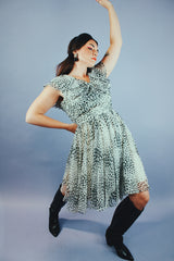 knee length sleeveless dress with ruffle neckline in a white and black polka dot print vintage 1970's