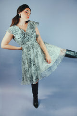 knee length sleeveless dress with ruffle neckline in a white and black polka dot print vintage 1970's