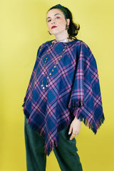 Women's vintage 1970's one size fits most navy and purple plaid print poncho with fringe hem trim and button closure on shoulder in acrylic material.