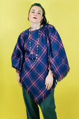Women's vintage 1970's one size fits most navy and purple plaid print poncho with fringe hem trim and button closure on shoulder in acrylic material.