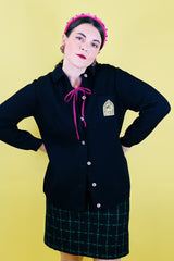 Women's vintage 1960's Dorce label long sleeve black wool button up cardigan with yellow patch with words La Costa on left chest.