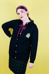 Women's vintage 1960's Dorce label long sleeve black wool button up cardigan with yellow patch with words La Costa on left chest.