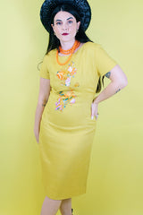 Women's vintage 1960's Jan Sue label short sleeve knee length shift dress in yellow cotton with multicolored floral print stitched on the front.