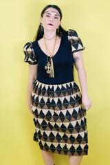 Women's vintage 1970's short sleeve puff sleeve midi length dress in cotton material. Black body with brown and tan printed sleeves and skirt.