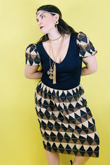 Women's vintage 1970's short sleeve puff sleeve midi length dress in cotton material. Black body with brown and tan printed sleeves and skirt.