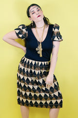 Women's vintage 1970's short sleeve puff sleeve midi length dress in cotton material. Black body with brown and tan printed sleeves and skirt.