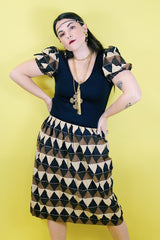 Women's vintage 1970's short sleeve puff sleeve midi length dress in cotton material. Black body with brown and tan printed sleeves and skirt.