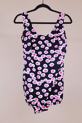 vintage 1960's one piece swimsuit in black with white and pink polka dots skirt in front over bottoms