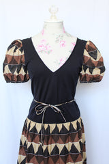 Women's vintage 1970's short sleeve puff sleeve midi length dress in cotton material. Black body with brown and tan printed sleeves and skirt.