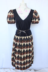 Women's vintage 1970's short sleeve puff sleeve midi length dress in cotton material. Black body with brown and tan printed sleeves and skirt.