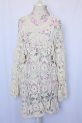 Women's vintage 1970's long sleeve white cream crochet dress with balloon sleeves and a V shaped neckline.