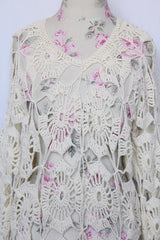 Women's vintage 1970's long sleeve white cream crochet dress with balloon sleeves and a V shaped neckline.