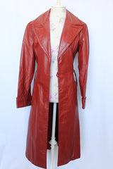 Women's vintage 1970's long length long sleeve leather wrap coat in maroon color. Double lapel, tie belt, pockets.