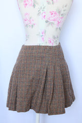 Women's vintage and retro 1990's Limited, Made in Italy label mini skirt in brown plaid print with a wrap front closure and four brown buttons.