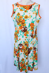 Women's vintage 1960's sleeveless knee length shift dress in off white with an all over floral print and orange trim.
