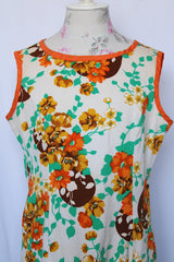 Women's vintage 1960's sleeveless knee length shift dress in off white with an all over floral print and orange trim.