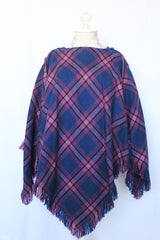 Women's vintage 1970's one size fits most navy and purple plaid print poncho with fringe hem trim and button closure on shoulder in acrylic material.