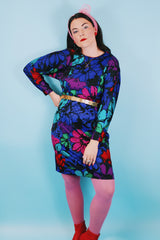 Women's vintage 1980's Blair, Warren, PA label long sleeve mini length polyester material dress in blue, pink, red, and green all over floral print. Dolman fit with elastic waistband.
