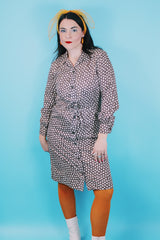 Women's vintage 1970's long sleeve knee length button up shirt dress in brown with all over white floral print.
