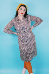 Women's vintage 1970's long sleeve knee length button up shirt dress in brown with all over white floral print.
