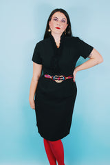 Women's vintage 1960's A Topaz Original label short sleeve knee length black polyester shift dress with a ruffle trim v shaped neckline.