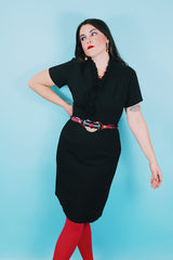 Women's vintage 1960's A Topaz Original label short sleeve knee length black polyester shift dress with a ruffle trim v shaped neckline.