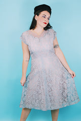 Women's vintage 1950's capped sleeved midi length lace fancy dress. Fully lined in lilac polyester with baby blue lace overlay.
