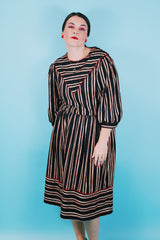 Women's vintage 1980's Walden Classics, Made in USA label 3/4 arm length midi length black striped dress with cinched waist, buttons on shoulders and triangle flap in front and back.