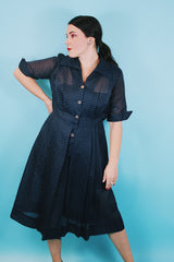Women's vintage 1950's short sleeve midi length navy blue sheer shirt dress with subtle checkered print.