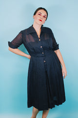 Women's vintage 1950's short sleeve midi length navy blue sheer shirt dress with subtle checkered print.