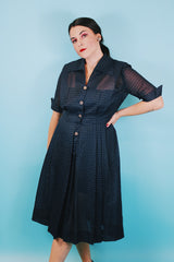 Women's vintage 1950's short sleeve midi length navy blue sheer shirt dress with subtle checkered print.