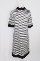 Women's vintage 1970's Mode O'Day, Styled in California label short sleeve mini length dress in black and white polyester material with diamond checkered print.