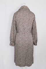 Women's vintage 1970's long sleeve knee length button up shirt dress in brown with all over white floral print.