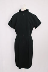 Women's vintage 1960's A Topaz Original label short sleeve knee length black polyester shift dress with a ruffle trim v shaped neckline.