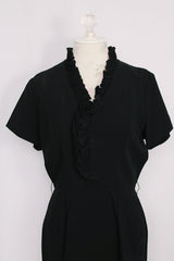 Women's vintage 1960's A Topaz Original label short sleeve knee length black polyester shift dress with a ruffle trim v shaped neckline.