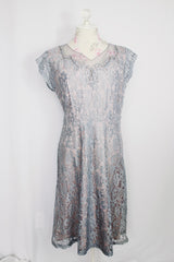 Women's vintage 1950's capped sleeved midi length lace fancy dress. Fully lined in lilac polyester with baby blue lace overlay.